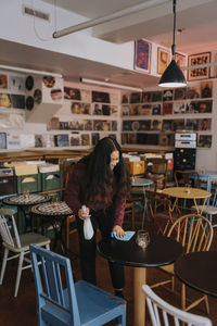 Smiling female entrepreneur with rag cleaning table in cafe