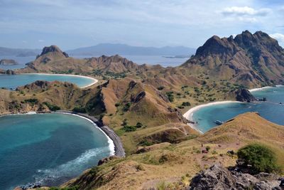 Scenic view of sea and mountains against sky