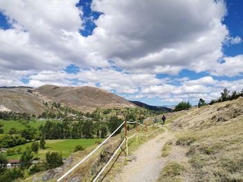 Road leading towards mountains against sky