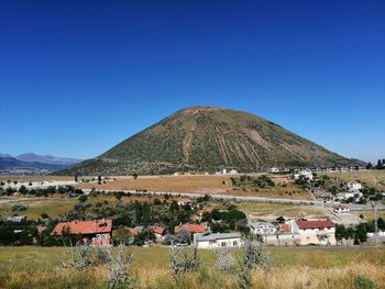 Houses on mountain against clear blue sky