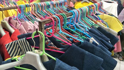 Multi colored clothes hanging at store for sale