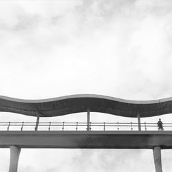 Low angle view of bridge against cloudy sky