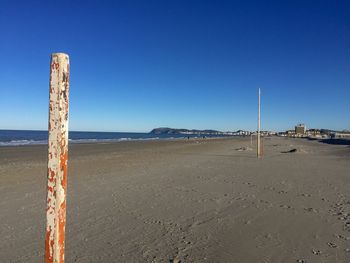 Scenic view of beach against clear blue sky