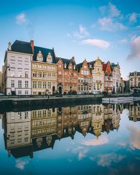 Reflection of buildings in lake against sky