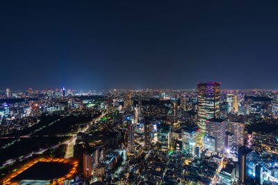 High angle view of illuminated city buildings against clear sky