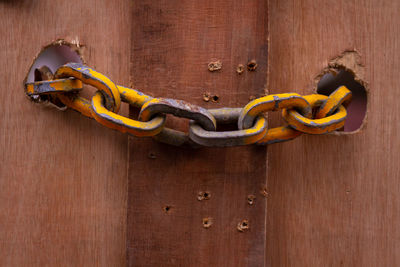 Close-up of metal chain on wooden door