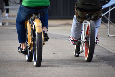 Low section of people riding bicycle on road