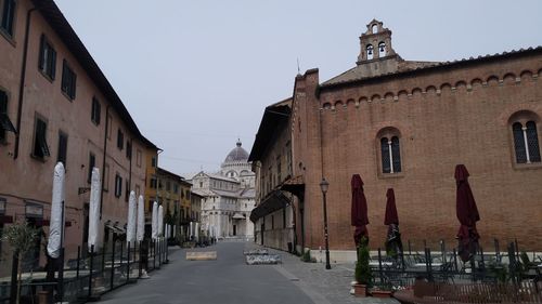 Street amidst buildings against sky in city
