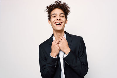 Portrait of smiling man standing against white background