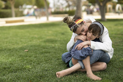 Rear view of mother and daughter on grass