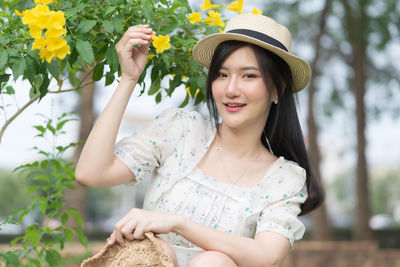 Portrait of smiling young woman holding hat