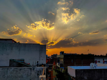 Buildings in town against sky during sunset