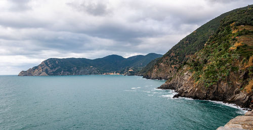 Scenic view of sea and mountains against sky