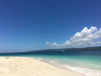 Scenic view of beach against blue sky