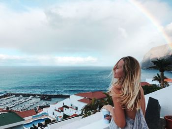 Woman looking at sea against sky