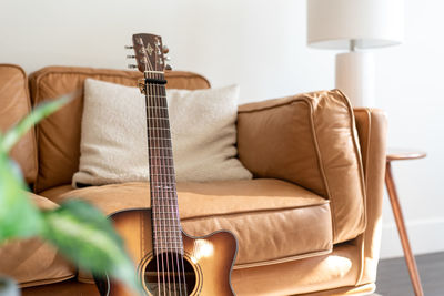 Low angle view of guitar on sofa at home