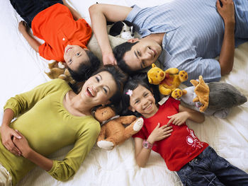 High angle portrait of happy family lying on mattress at home