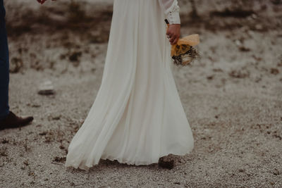 Low section of bride standing on field