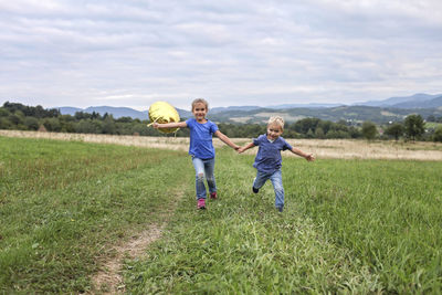 Boy running on grassy field