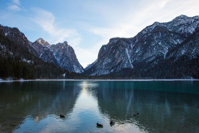 Scenic view of lake by mountains against sky