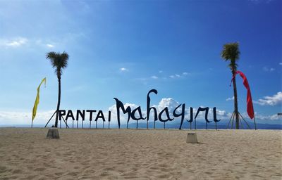 Text on beach against sky