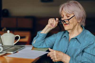 Senior woman with eyeglasses looking at document