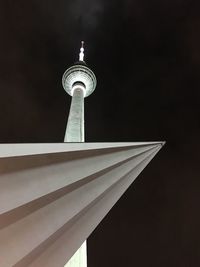 Low angle view of communications tower in city against sky