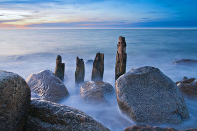Panoramic shot of rocks in sea against blue sky
