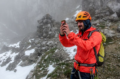 Man playing pokémon go on rocky mountain