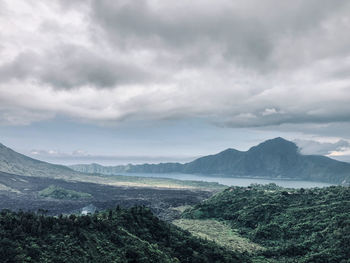 Scenic view of landscape and mountains by lake against sky