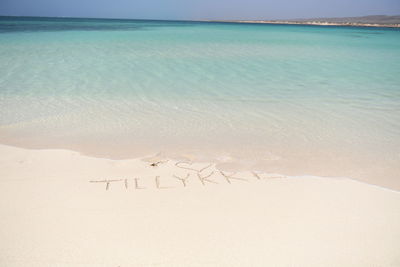 Scenic view of text on beach against sky