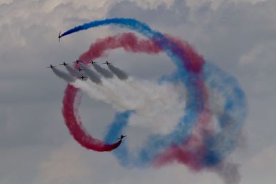 Low angle view of airshow against sky