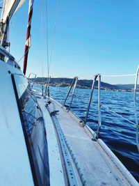 Sailboats sailing in sea against clear blue sky