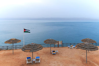 High angle view of canopies and flag against sea