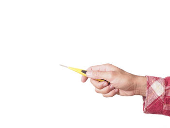 Close-up of hand holding paper over white background