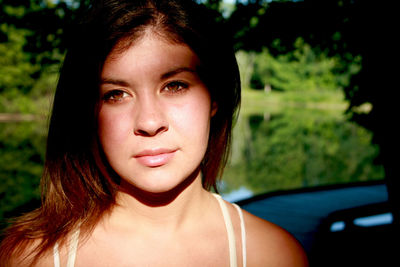 Close-up portrait of beautiful young woman standing at park