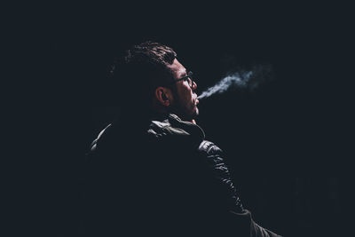 Full length of young man smoking at night