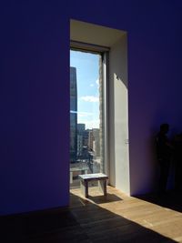 Rear view of man standing by window in building