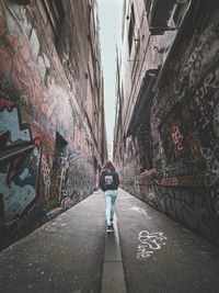 Rear view of woman walking on alley