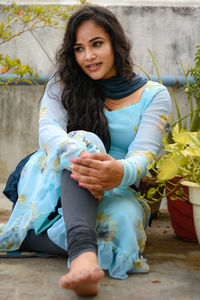 Portrait of smiling young woman sitting on sofa