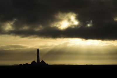 Silhouette of building against cloudy sky