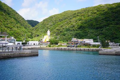 Scenic view of river amidst buildings against sky