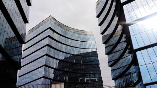 Low angle view of modern glass building against sky