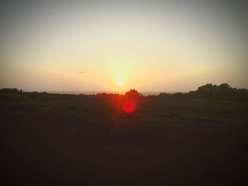 Scenic view of field against clear sky during sunset