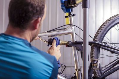 Mid adult man repairing bicycle at garage