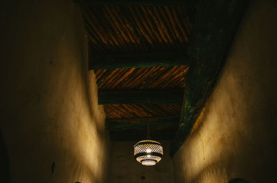 Low angle view of illuminated lights hanging on ceiling in building