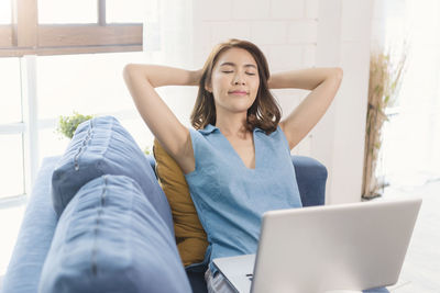 Young woman using mobile phone at home