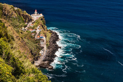 High angle view of man on rock by sea