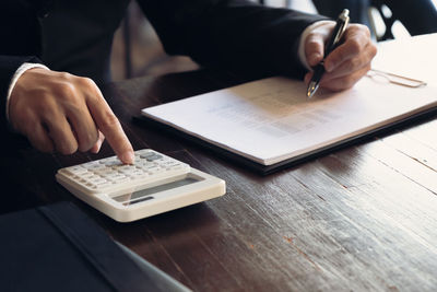 Midsection of man using mobile phone on table