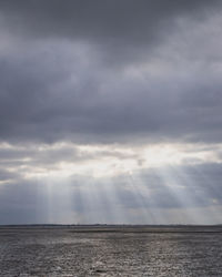 Scenic view of sea against storm clouds